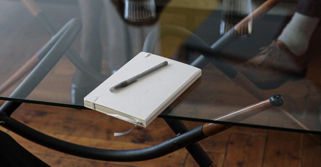 Close-up of a counseling session with two glasses of water and a notepad on a glass table.